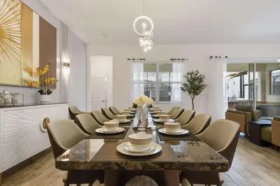 a large dining room with a long table and chairs at Spacious 12BR Disney Themed Home Pool/SPA/BBQ/Game in Kissimmee