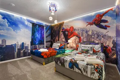 a bedroom with two beds and a superhero mural at NEW Disney Themed 12BR Home Pool/SPA/Game/Tiki Bar in Kissimmee