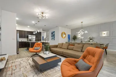 a living room with a couch and a dining room at NEW Disney Themed 12BR Home Pool/SPA/Game/Tiki Bar in Kissimmee