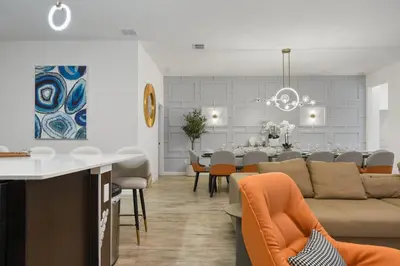 a living room and dining room with a couch and a table at NEW Disney Themed 12BR Home Pool/SPA/Game/Tiki Bar in Kissimmee
