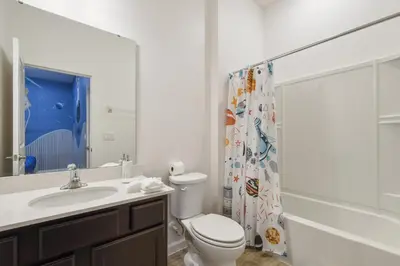 a bathroom with a toilet and a sink and a shower at NEW Disney Themed 12BR Home Pool/SPA/Game/Tiki Bar in Kissimmee