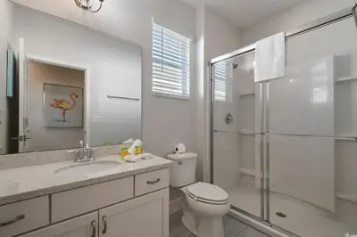 a white bathroom with a toilet and a shower at Elegant Home with Pool & Spa, Close to Disney in Kissimmee