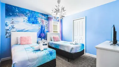 a blue bedroom with two beds and a tv at Disney-Themed Oasis with Private Pool & Spa in Kissimmee