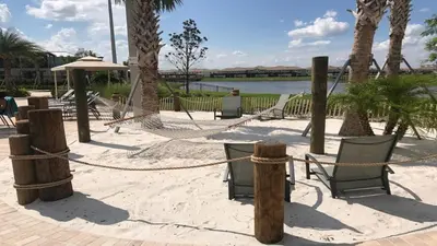 a beach with hammocks and chairs on the sand at Elegant Retreat with Private Spa & Pool in Kissimmee