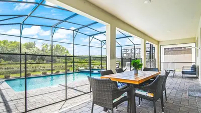 a conservatory with a table and chairs and a pool at Elegant Retreat with Private Spa & Pool in Kissimmee