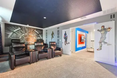 a living room with leather chairs and paintings on the walls at Storey Lake Getaway Pool SPA Theater in Kissimmee