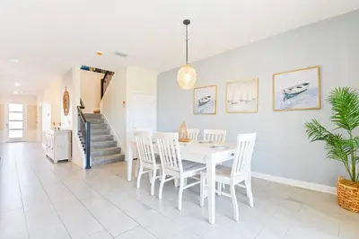 a dining room with a white table and chairs at Resort Home: Game Room, Pool, Near Disney in Kissimmee