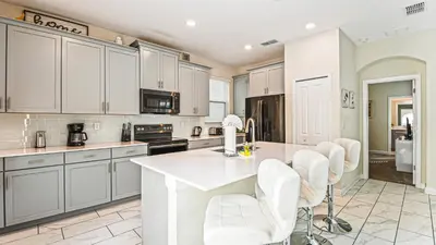 a kitchen with white cabinets and a white counter top at Storey Lake Cozy Resort Home Pool Spa Disney Theme in Kissimmee