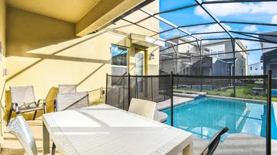 a balcony with a table and chairs and a swimming pool at Storey Lake Cozy Resort Home Pool Spa Disney Theme in Kissimmee