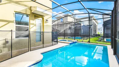 a swimming pool in the backyard of a house with a building at Storey Lake Cozy Resort Home Pool Spa Disney Theme in Kissimmee