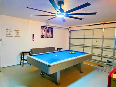 a pool table in a room with a ceiling fan at Lakeview Luxury Oasis in Kissimmee