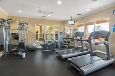 a gym with treadmills and machines in a room at C2821-303 Windsor Hills Resort 3 Bedrm Water Park in Orlando