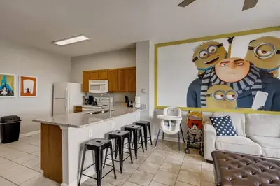 a kitchen with a bar with stools and a couch at T7673F Windsor Hills Resort 3Bed POOL Pet Friendly in Orlando