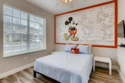a bedroom with a mickey mouse painting on the wall at T7674O Windsor Hills Resort 3Bedrm 2miles Disney in Orlando
