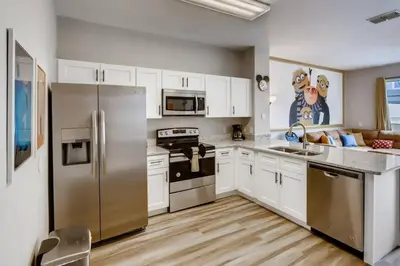 a kitchen with stainless steel appliances and white cabinets at T7674O Windsor Hills Resort 3Bedrm 2miles Disney in Orlando