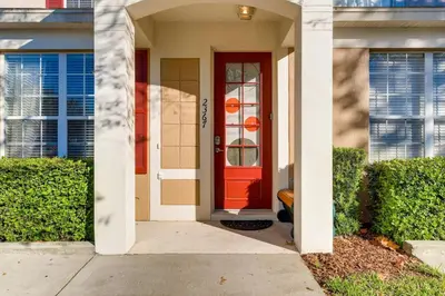 a red front door of a house with bushes at T2367 Windsor Palm Resort Pool 3 miles to Disney in Kissimmee