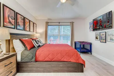 a bedroom with a bed with a red comforter and a window at H8438S Emerald Island Resort One Level POOL Pet OK in Kissimmee