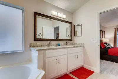a bathroom with a tub and a sink and a mirror at H8438S Emerald Island Resort One Level POOL Pet OK in Kissimmee