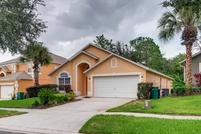 a house with a driveway and palm trees at H8438S Emerald Island Resort One Level POOL Pet OK in Kissimmee