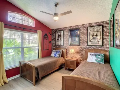 a bedroom with two beds and a brick wall at H8536 Single Level Pool Spa Home 5 Bed Near Disney in Kissimmee