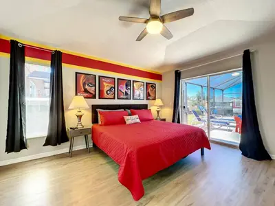 a bedroom with a red bed and a ceiling fan at H2631E Resort Single Level POOL SPA Home Disney in Kissimmee