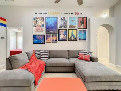 a living room with a couch and posters on the wall at H2553O Single Level 5 Bedrm Pool 3Miles Disney in Kissimmee