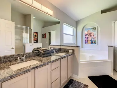 a bathroom with two sinks and a tub and a large mirror at H2553O Single Level 5 Bedrm Pool 3Miles Disney in Kissimmee