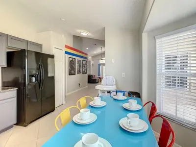a kitchen with a blue table with chairs and a refrigerator at H2553O Single Level 5 Bedrm Pool 3Miles Disney in Kissimmee