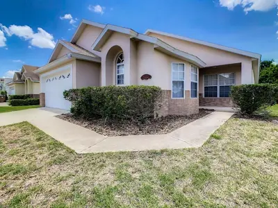 a large house with a white garage at H2553O Single Level 5 Bedrm Pool 3Miles Disney in Kissimmee