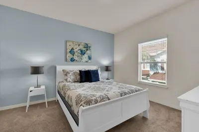 a white bedroom with a bed and a window at 3206 Gold in Kissimmee
