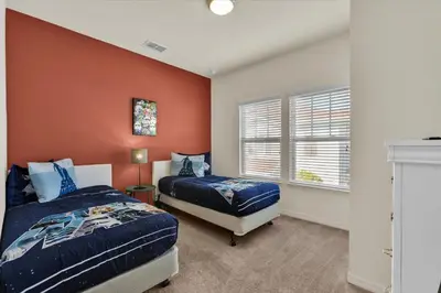a bedroom with two beds and an orange wall at 3206 Gold in Kissimmee