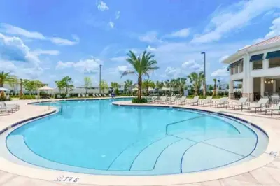 a large pool with chairs and a building at Magic Marvel Getaway in Kissimmee