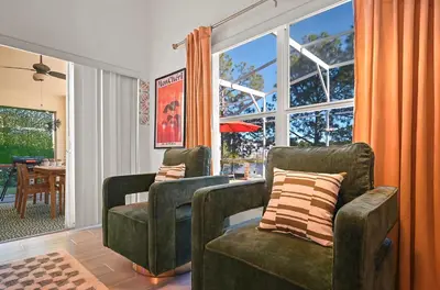 a living room with two chairs and a window at Disney World Getaway: 4 Br - Sunroof - BBQ Bliss in Orlando