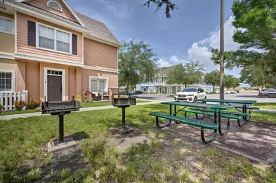a group of picnic tables in front of a house at Haven Beautiful 3 BR TH in Gated Resort Community in Kissimmee