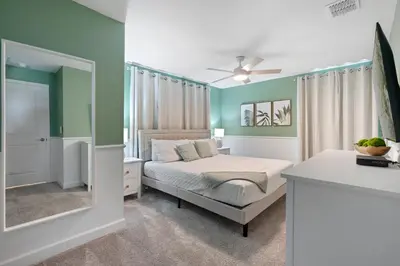 a bedroom with a bed and a mirror at New Home 5 Bedrooms and 4 Bathrooms At Storey Lake in Kissimmee