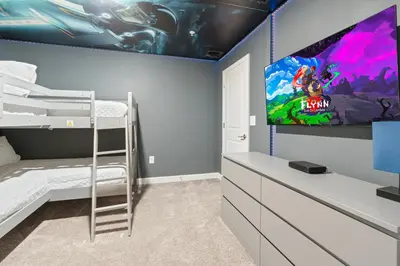 a bedroom with a bunk bed and a flat screen tv at New Home 5 Bedrooms and 4 Bathrooms At Storey Lake in Kissimmee