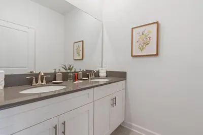 a bathroom with two sinks and a mirror at New Home 5 Bedrooms and 4 Bathrooms At Storey Lake in Kissimmee