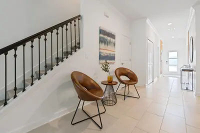 a hallway with two chairs and a table at New Home 5 Bedrooms and 4 Bathrooms At Storey Lake in Kissimmee