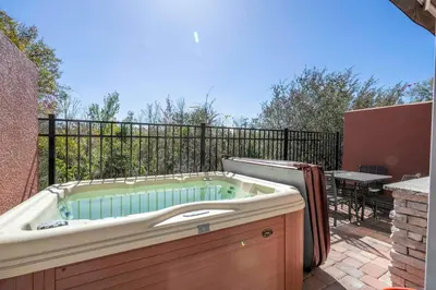 a jacuzzi tub on a patio with a table at Awesome 4 Suites Villa 5 Min to Disney in Orlando