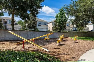 a playground with yellow play equipment in a park at Living the dream Windsor Hills Resort in Orlando