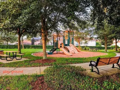 a park with a playground with benches and a slide at Living the dream Windsor Hills Resort in Orlando