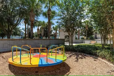 a colorful playground in a park with trees at Living the dream Windsor Hills Resort in Orlando