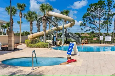 a slide in a pool at a resort with palm trees at Living the dream Windsor Hills Resort in Orlando