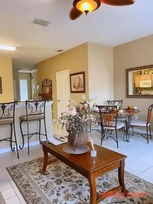 a living room with a vase of flowers on a table at Living the dream Windsor Hills Resort in Orlando
