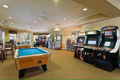 a room with a pool table and arcade games at Living the dream Windsor Hills Resort in Orlando