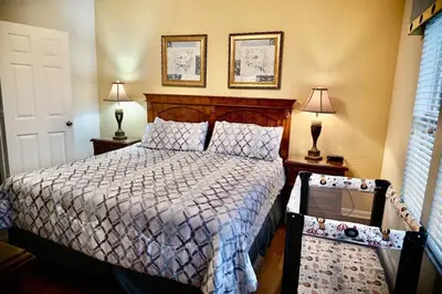a bedroom with a bed and two lamps and a window at Living the dream Windsor Hills Resort in Orlando