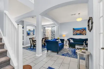 a living room with white walls and blue furniture at 8462 Secret Key Cove in Kissimmee