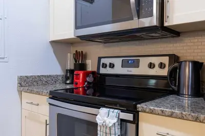 a kitchen with a stove and a microwave at Fabulous townhome near the Parks in Kissimmee