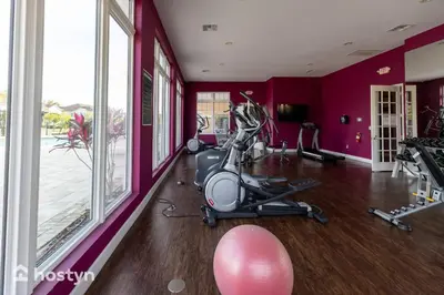 a gym with a exercise bike in a room with purple walls at Fabulous townhome near the Parks in Kissimmee
