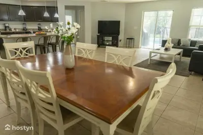a kitchen and living room with a wooden table and chairs at Beautiful vacation home near Disney in Kissimmee